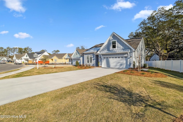 view of front of property with a front lawn, board and batten siding, fence, and a residential view