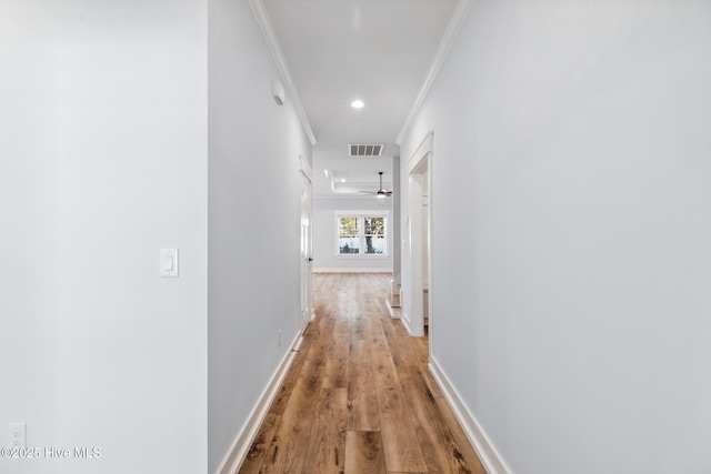 corridor featuring recessed lighting, visible vents, baseboards, light wood-style floors, and crown molding