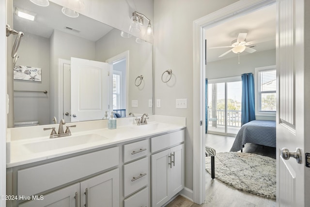 bathroom with wood-type flooring, vanity, toilet, and ceiling fan