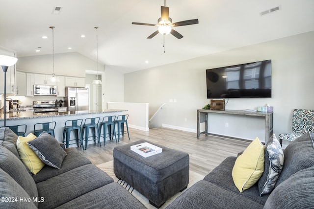 living room with ceiling fan, lofted ceiling, sink, and light hardwood / wood-style flooring