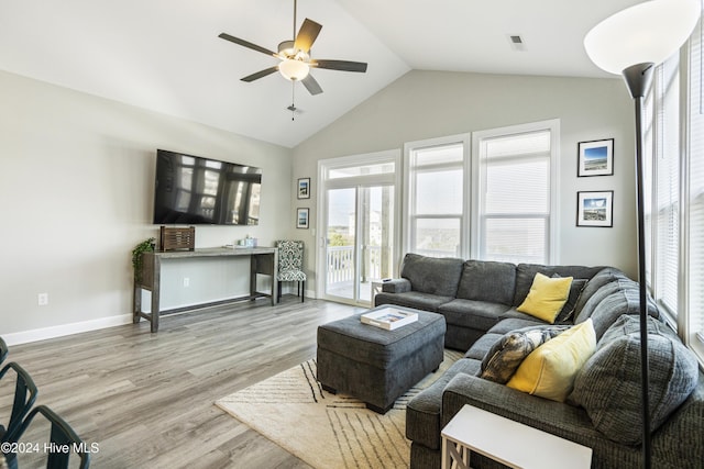 living room with ceiling fan, lofted ceiling, and light wood-type flooring