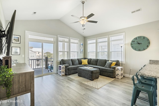 living room featuring light hardwood / wood-style floors, vaulted ceiling, plenty of natural light, and ceiling fan