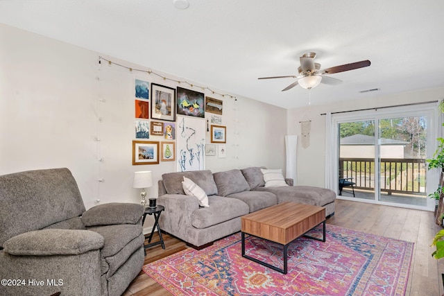 living room with wood-type flooring and ceiling fan