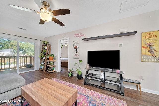 living room featuring wood-type flooring, a textured ceiling, and ceiling fan