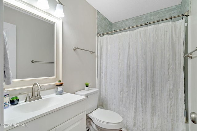 bathroom with vanity, curtained shower, toilet, and a textured ceiling