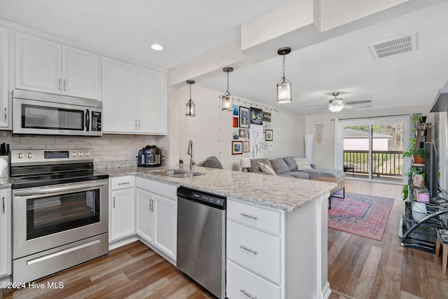 kitchen with white cabinetry, sink, stainless steel appliances, and light wood-type flooring