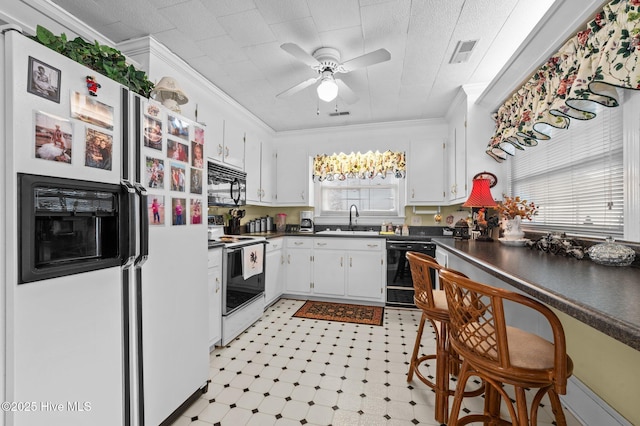 kitchen with sink, white cabinetry, black appliances, and ornamental molding