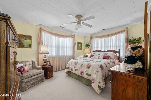 carpeted bedroom with ceiling fan and crown molding