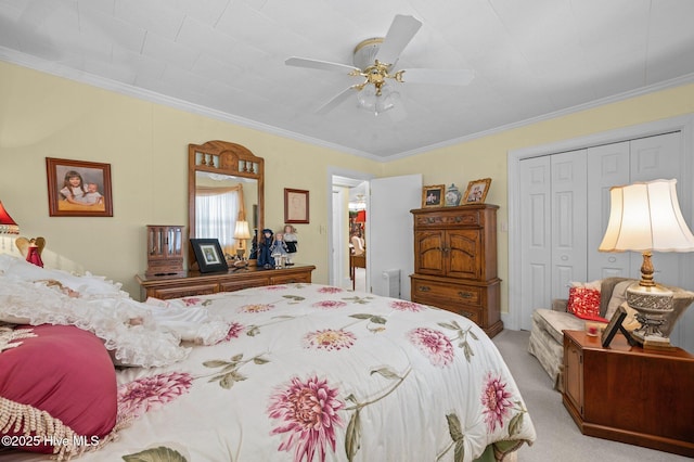 carpeted bedroom with ceiling fan, ornamental molding, and a closet