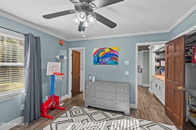 bedroom featuring a textured ceiling, crown molding, ceiling fan, and dark wood-type flooring