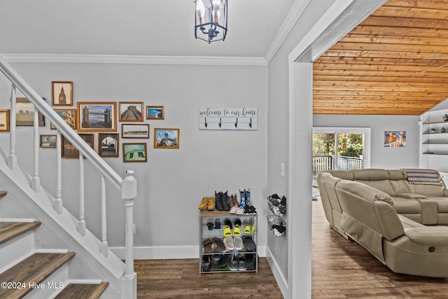 stairway with hardwood / wood-style floors, a textured ceiling, crown molding, and vaulted ceiling