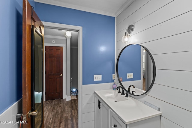 bathroom with hardwood / wood-style flooring, vanity, and crown molding