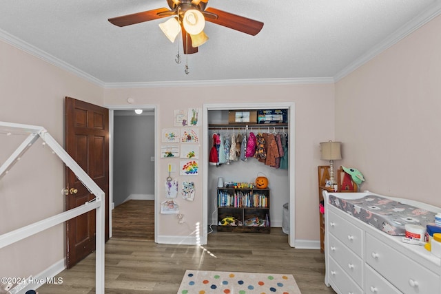 bedroom featuring ceiling fan, a closet, ornamental molding, and hardwood / wood-style flooring