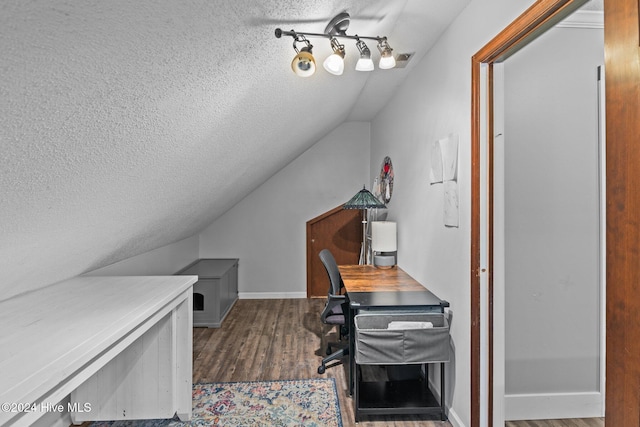 office area with a textured ceiling, dark wood-type flooring, and vaulted ceiling