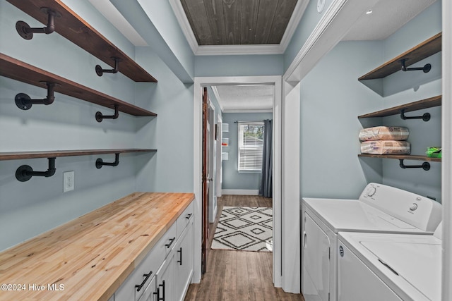 laundry room with hardwood / wood-style flooring, washer and clothes dryer, cabinets, and ornamental molding