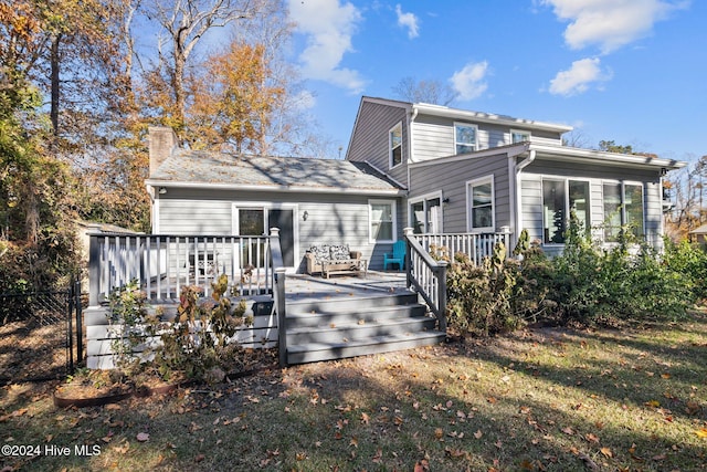 rear view of property with a yard and a deck