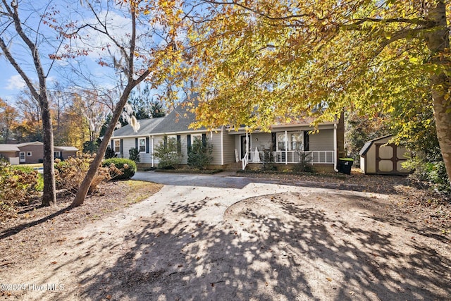 view of front facade featuring covered porch and a storage shed