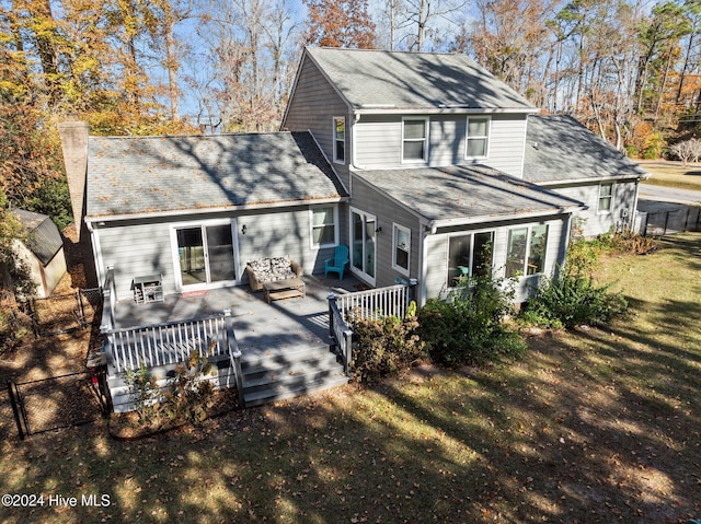 back of property with a lawn and a deck