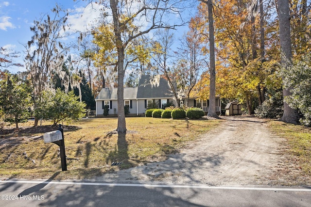 new england style home with a storage shed