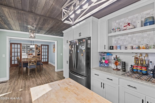 kitchen with light stone countertops, french doors, dark hardwood / wood-style floors, white cabinetry, and stainless steel refrigerator