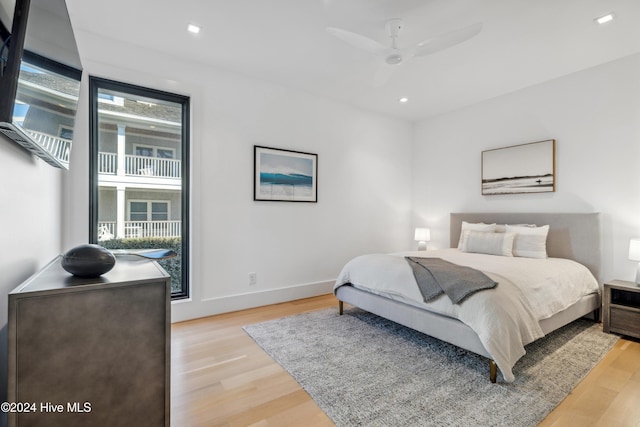 bedroom featuring ceiling fan, light wood-type flooring, and multiple windows