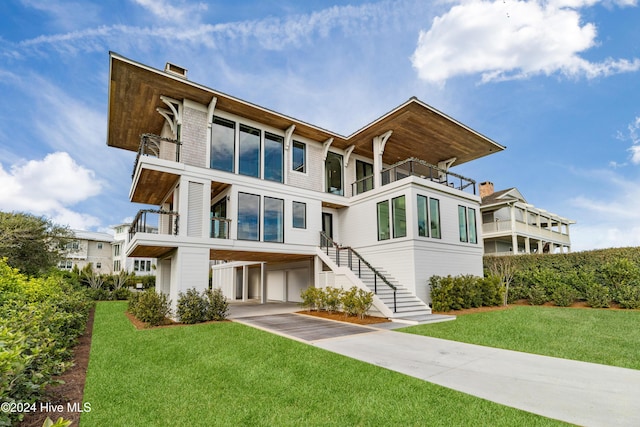 rear view of property featuring a balcony and a yard