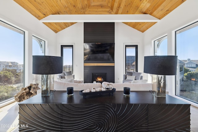 living room featuring a fireplace, plenty of natural light, and wood ceiling