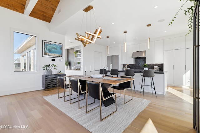 dining room featuring wood ceiling, light hardwood / wood-style flooring, and vaulted ceiling