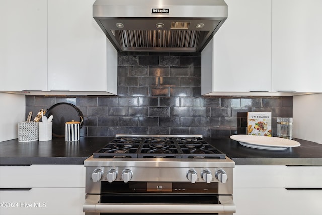 kitchen with backsplash, white cabinets, extractor fan, and stainless steel range with gas stovetop