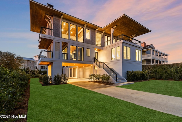 view of front of house with a lawn and a balcony