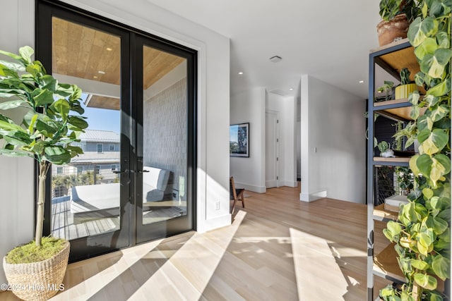 doorway with light wood-type flooring and french doors