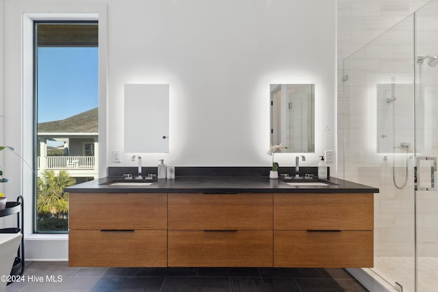 bathroom featuring tile patterned flooring, vanity, and a shower with shower door