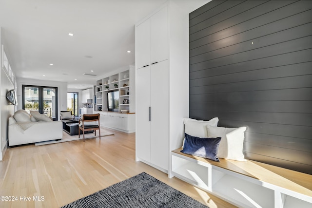 interior space with french doors, built in features, and light hardwood / wood-style flooring