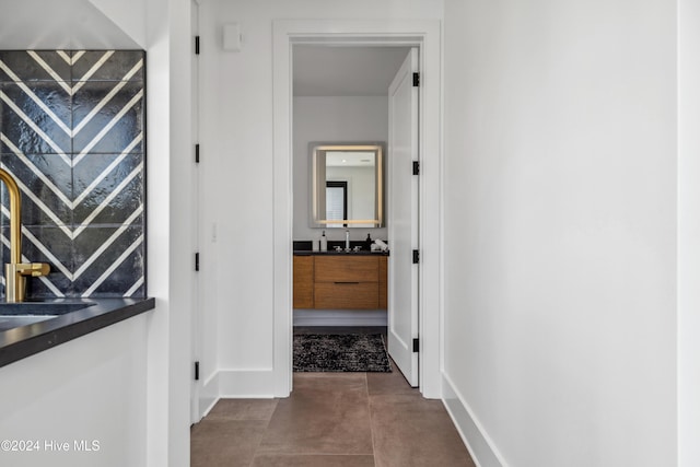 hall with tile patterned flooring and sink