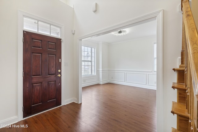 entryway featuring crown molding and dark wood-type flooring