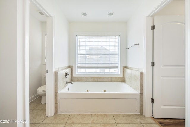 bathroom with a tub, tile patterned flooring, and toilet