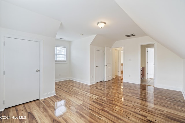 bonus room with vaulted ceiling and hardwood / wood-style flooring