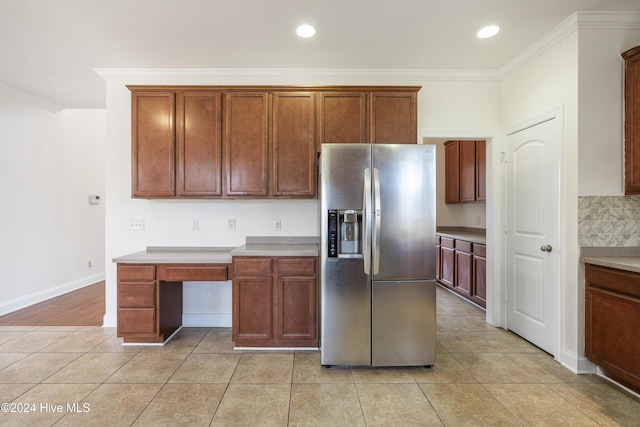 kitchen with decorative backsplash, stainless steel fridge, light tile patterned floors, and crown molding