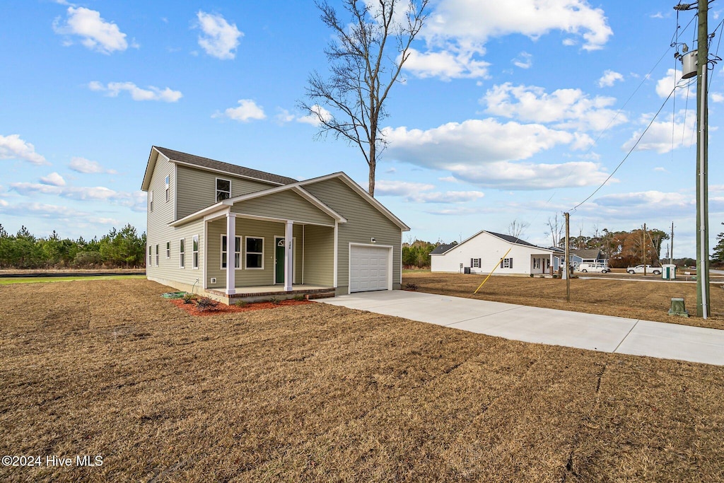 view of front of home with a porch, a garage, and a front lawn