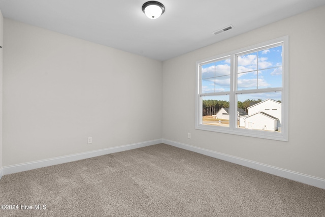 carpeted empty room featuring visible vents and baseboards