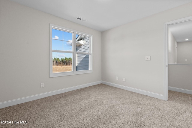 carpeted spare room featuring visible vents and baseboards