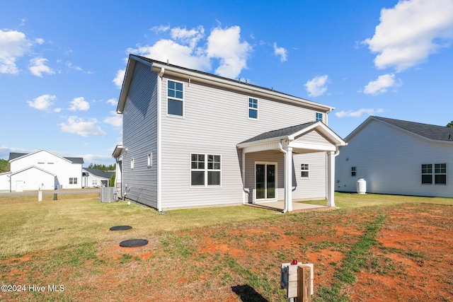 rear view of house featuring a yard, cooling unit, and a patio area