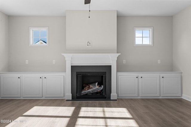 unfurnished living room featuring a fireplace with flush hearth and wood finished floors