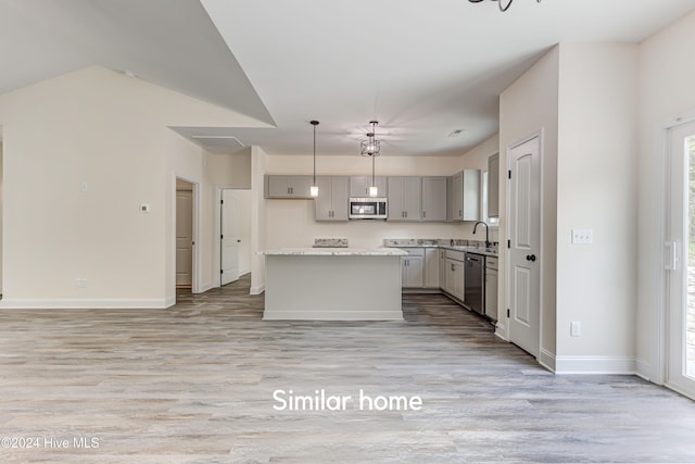 kitchen with light hardwood / wood-style flooring, a kitchen island, stainless steel appliances, and gray cabinetry