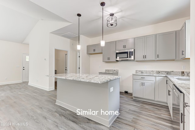 kitchen with gray cabinetry, a center island, stainless steel appliances, and light hardwood / wood-style flooring