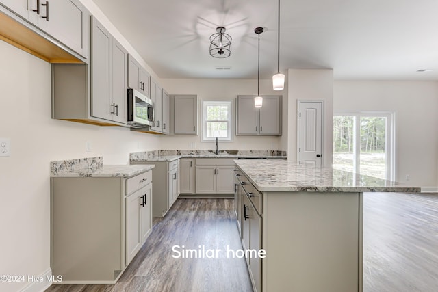 kitchen featuring wood-type flooring, gray cabinets, a wealth of natural light, and pendant lighting