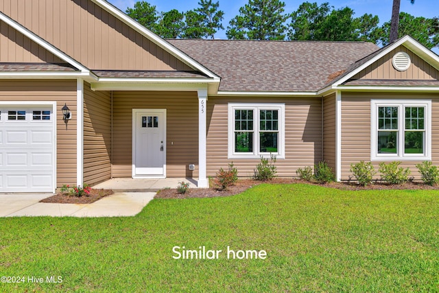 view of front of home with a front yard and a garage