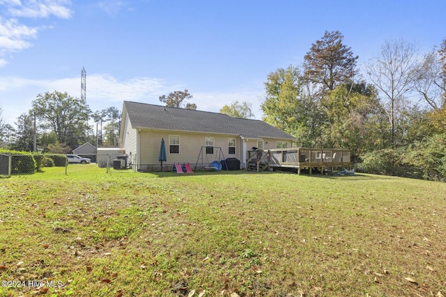 rear view of house featuring a yard and a deck