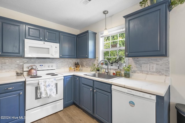 kitchen with blue cabinetry, sink, pendant lighting, white appliances, and wood-type flooring