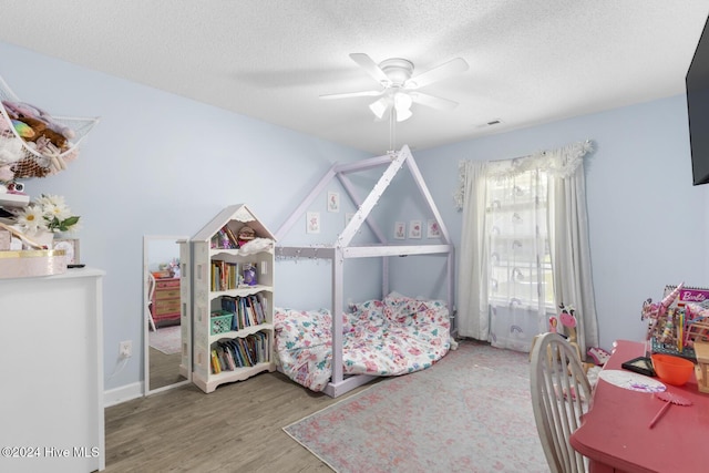 bedroom with wood-type flooring, a textured ceiling, and ceiling fan